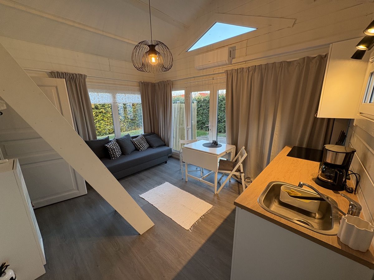 Vardagsrum och matplats med stege till loftet